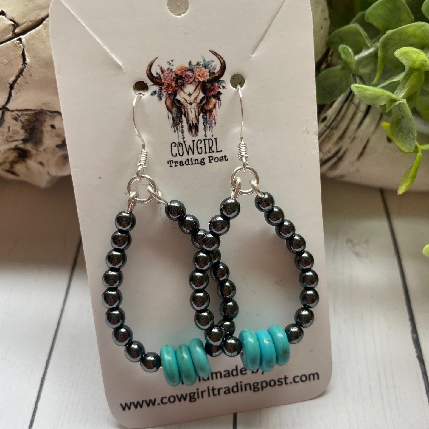 Gunmetal Colored Round and Turquoise Bead Teardrop Earrings o a white card with cowgirl trading post on  it
