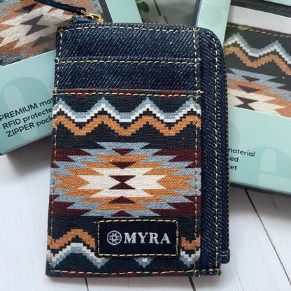 Denim cardholder with geometric pattern and 'MYRA' branding on a white surface.