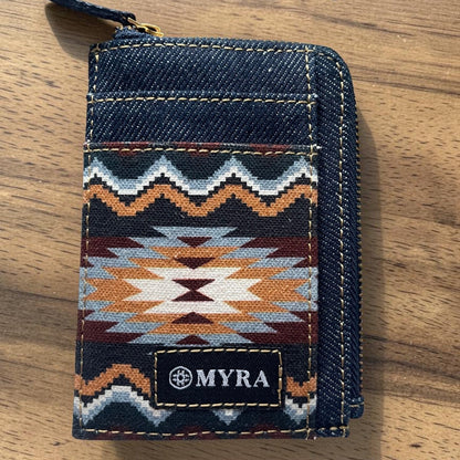Denim wallet with geometric pattern and 'MYRA' brand logo on a wooden surface