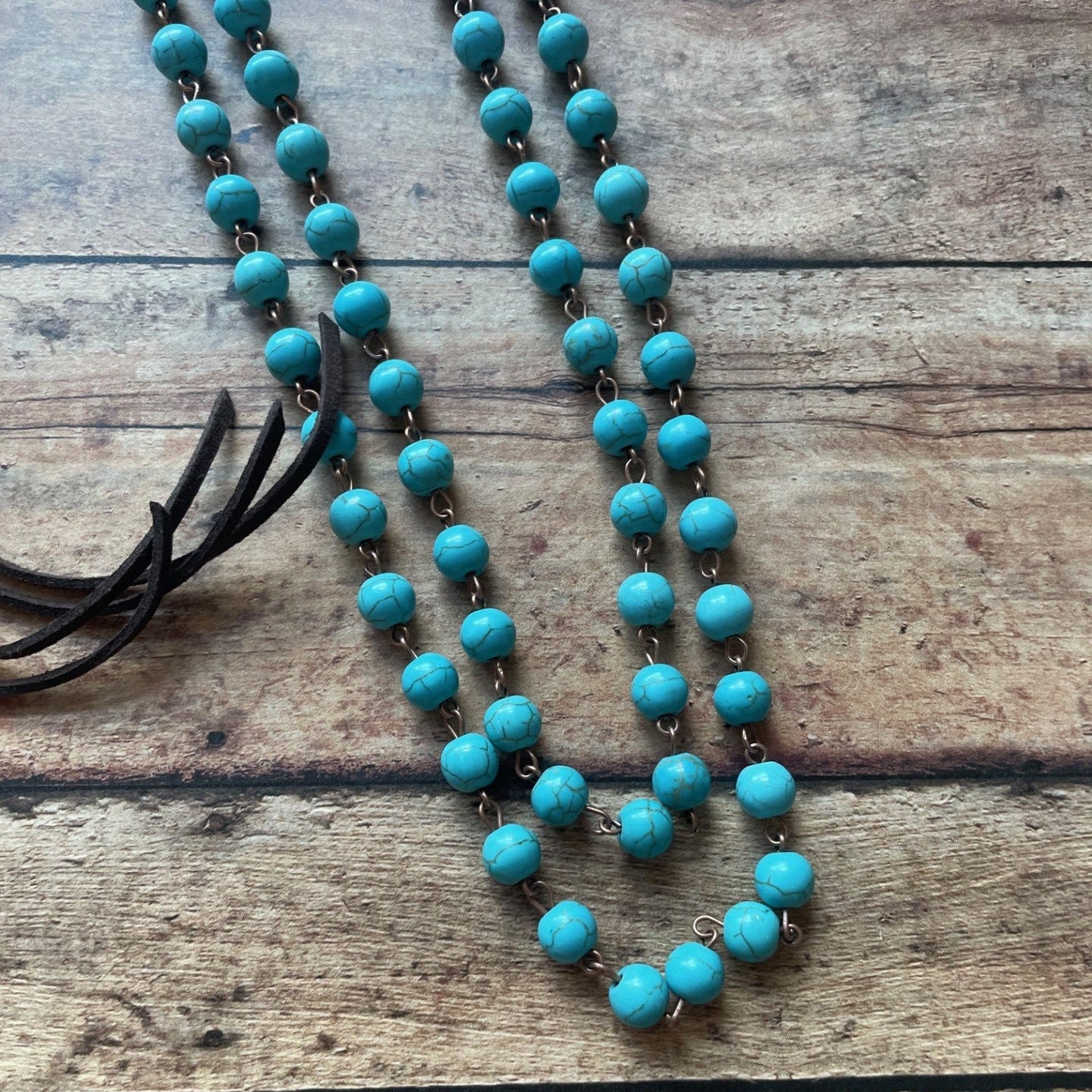 Turquoise beaded necklace on a wooden surface