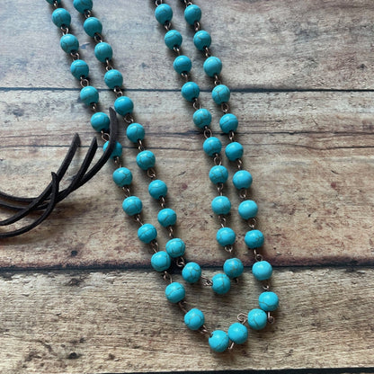 Turquoise beaded necklace on a wooden surface