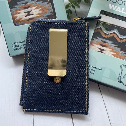 Denim wallet with gold money clip on a white surface with greenery in the background