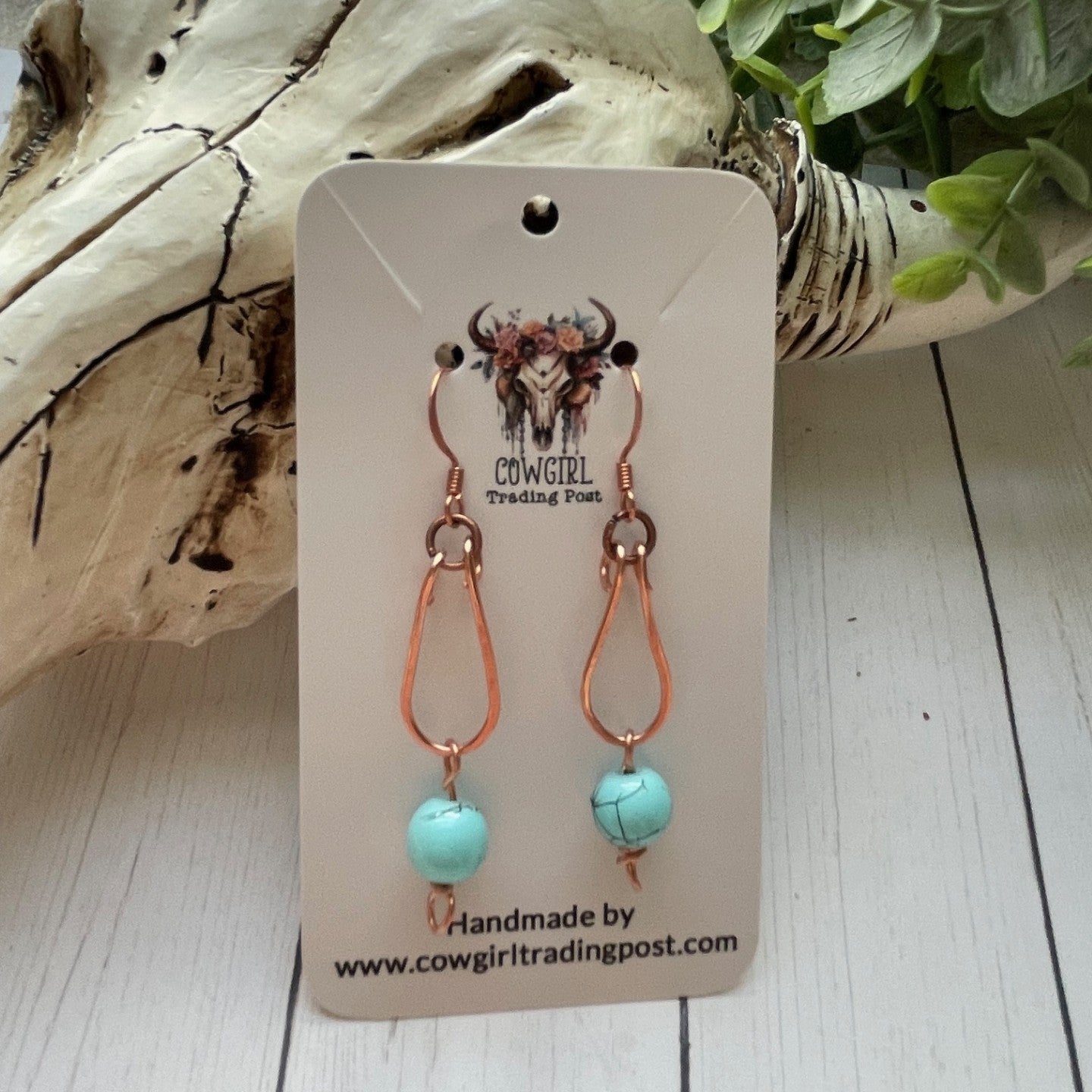 Copper Loop with a Turquoise colored bead hanging from copper colored earrings