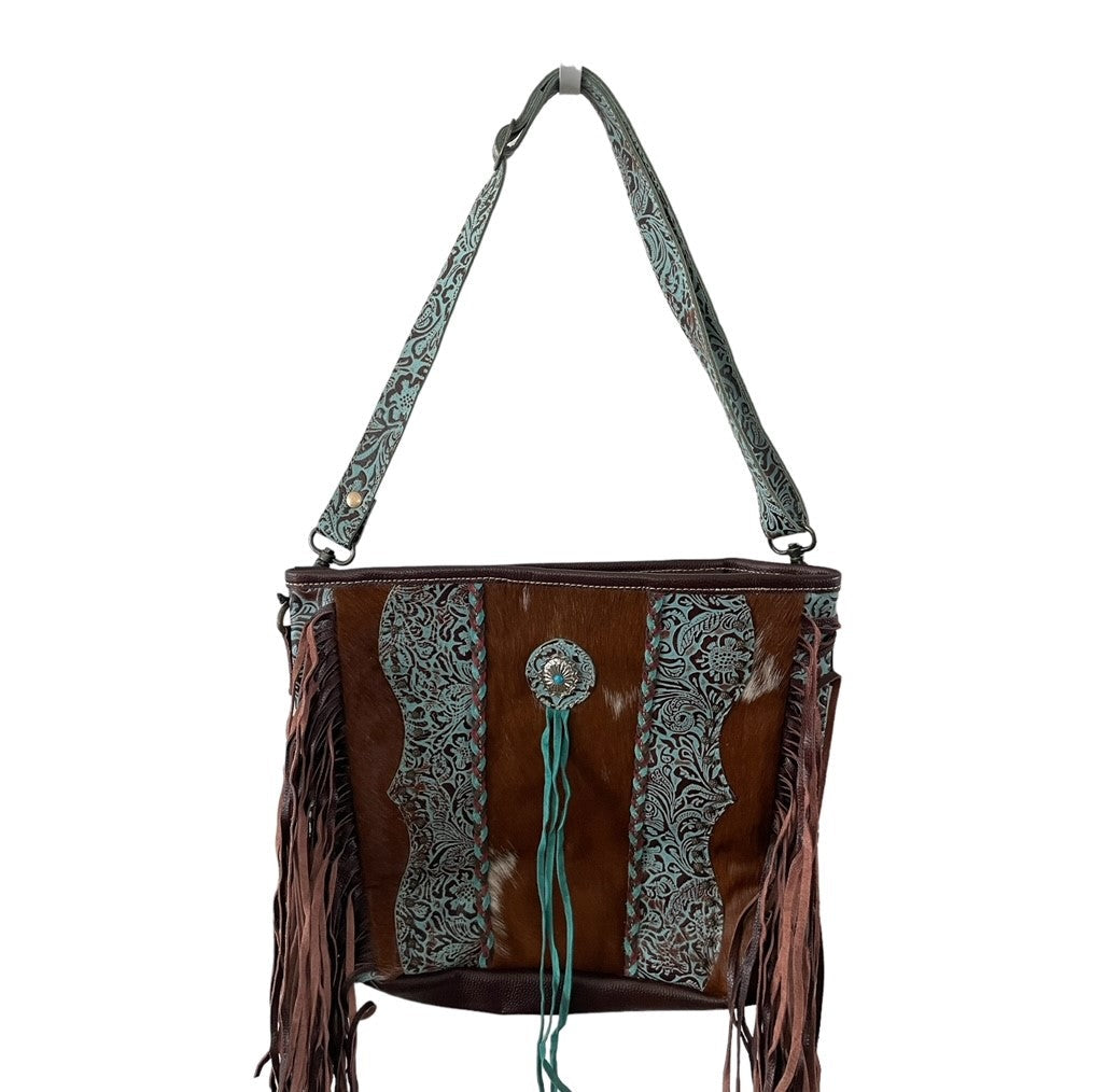 Brown leather handbag with intricate patterns and fringes on a white background
