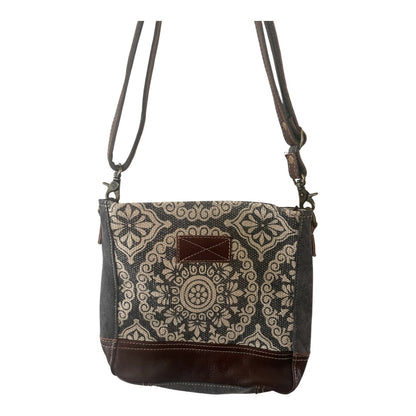 Patterned crossbody bag with brown accents on a white background