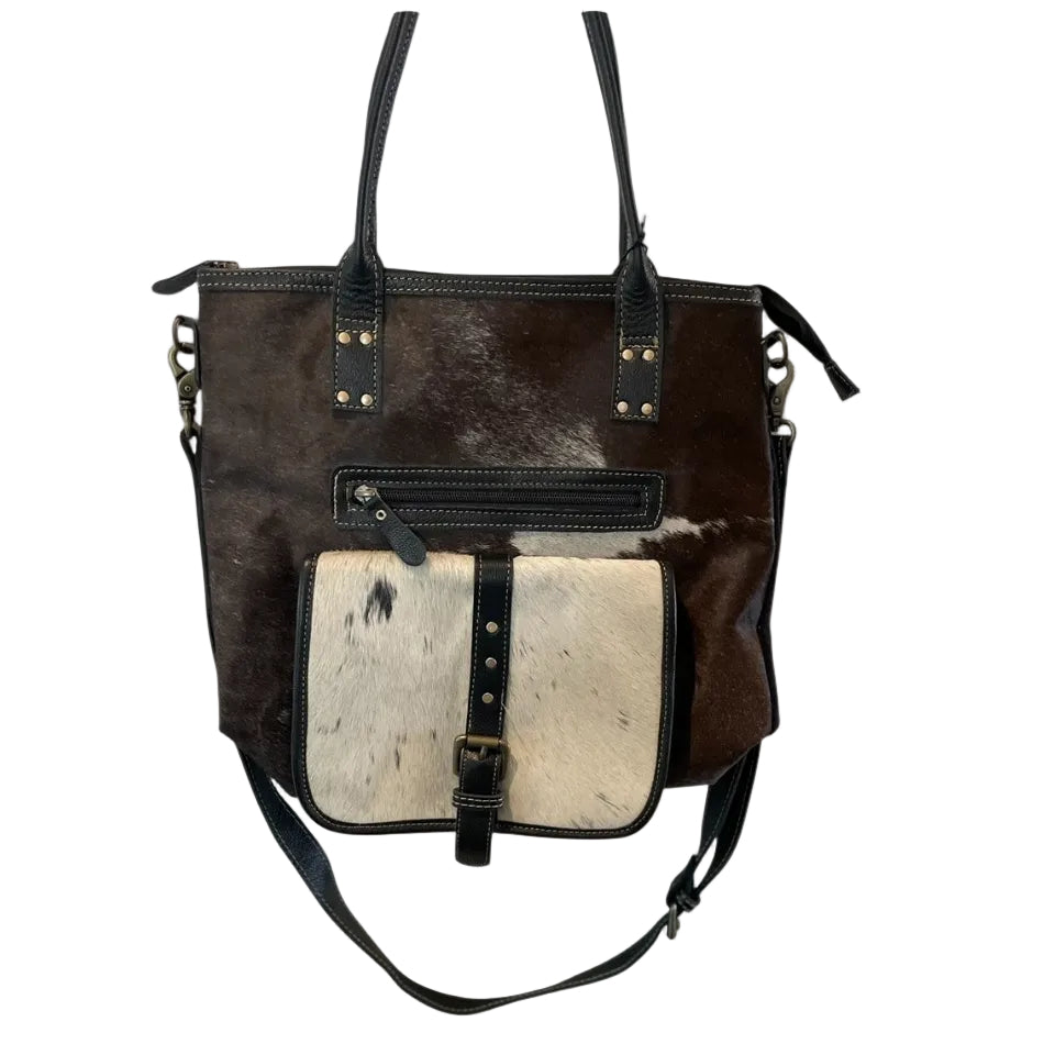 Brown and black leather handbag with a contrasting white section on a white background