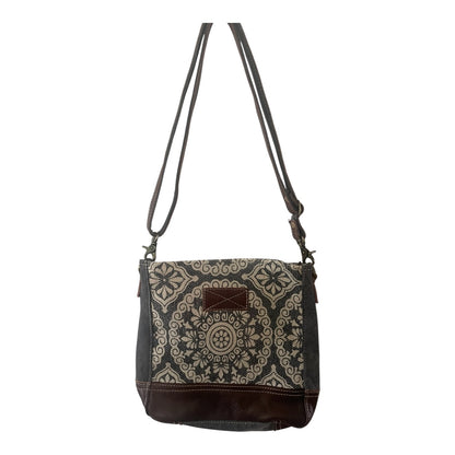 Patterned shoulder bag with brown accents on a white background