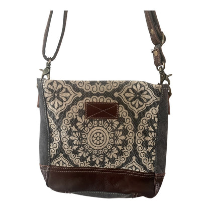 Patterned shoulder bag with brown accents on a white background