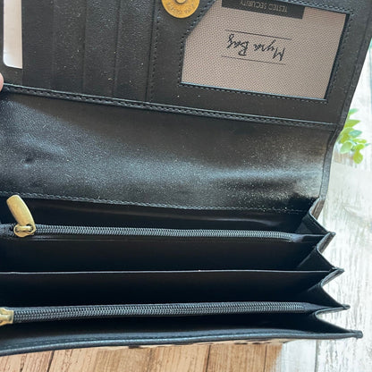 Black leather wallet with gold accents on a wooden surface