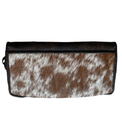 Clutch bag with brown and white cowhide pattern on a white background