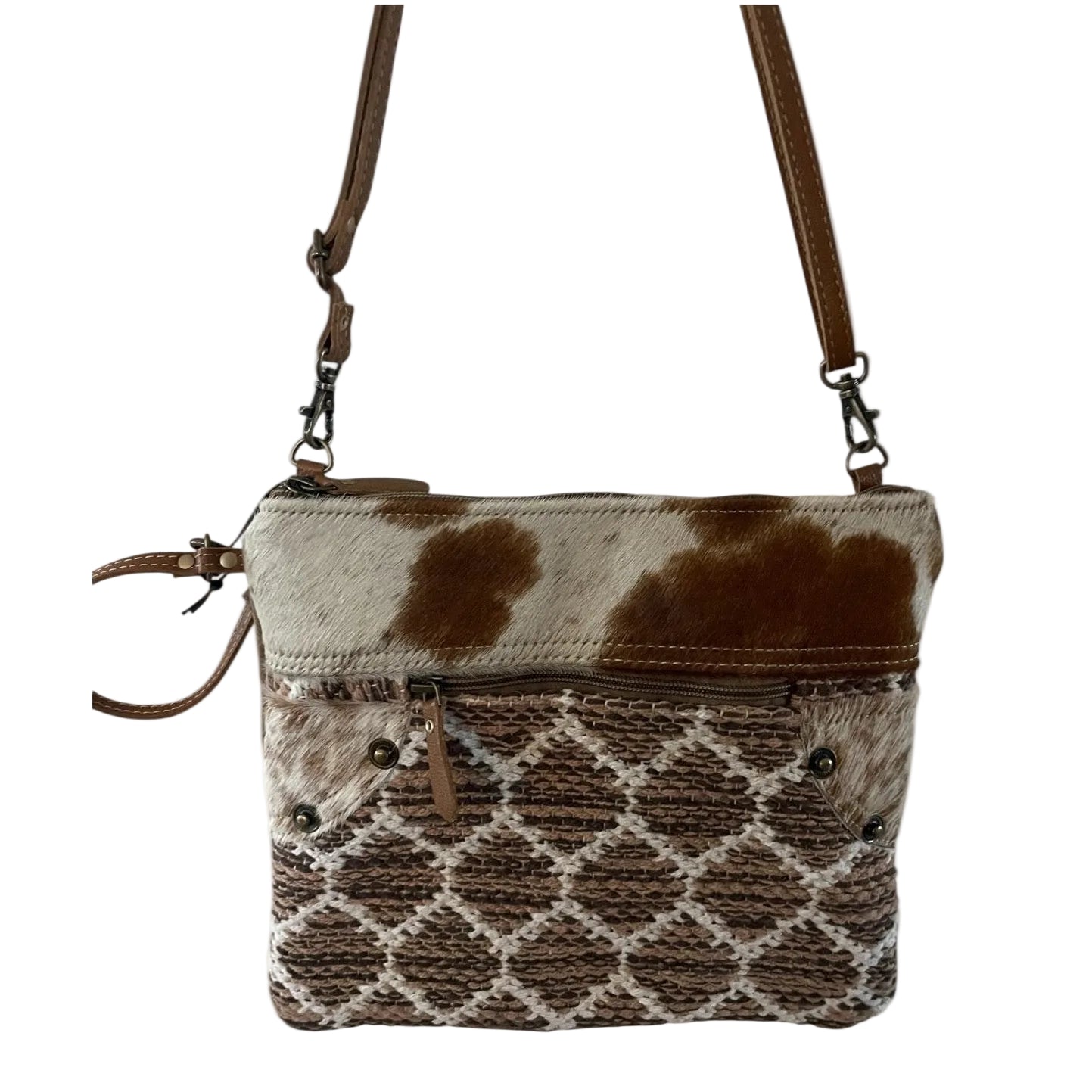 Crossbody bag with cow print pattern on a white background