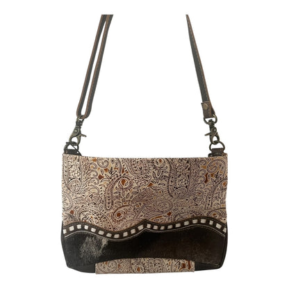 Patterned handbag with brown strap on a white background