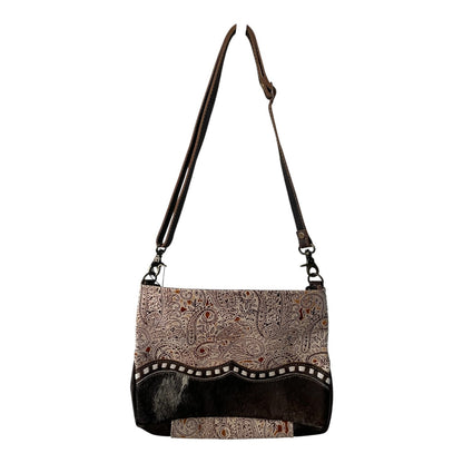 Handbag with patterned top and black bottom section on a white background