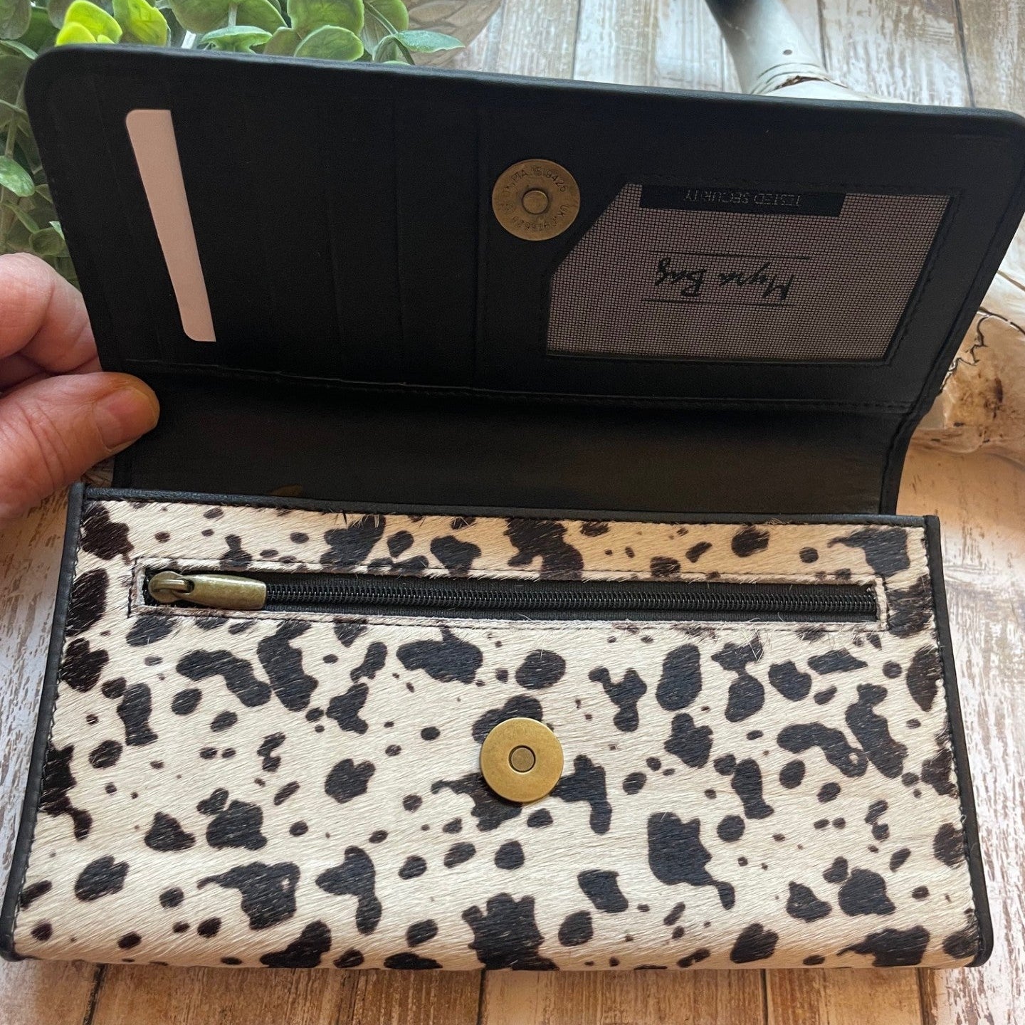 Open wallet with leopard print pattern on a wooden surface