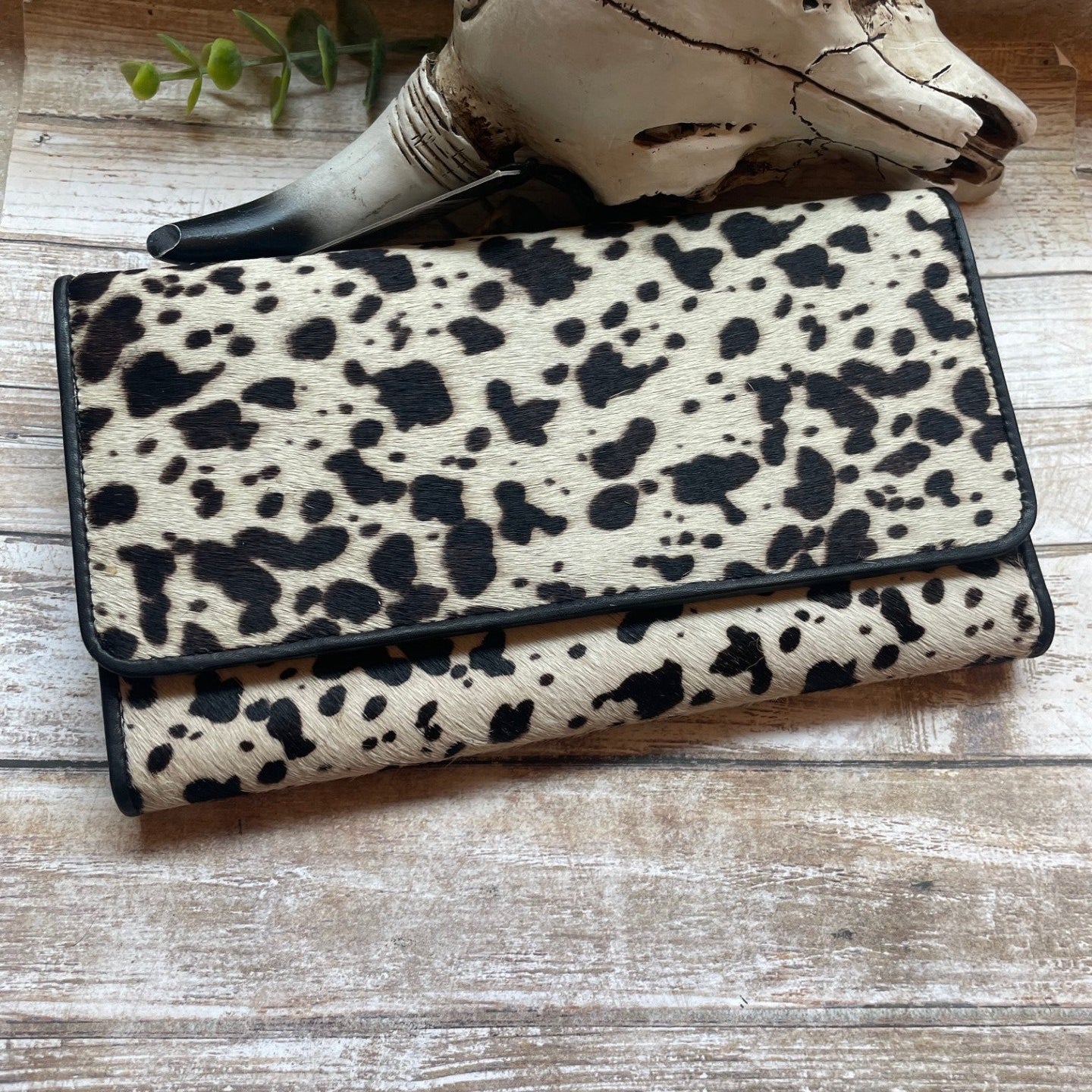 Leopard print wallet on a wooden surface with a rustic background