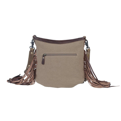 Beige handbag with brown leather fringe on a white background