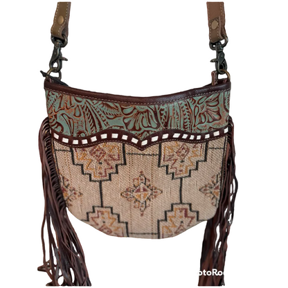 Patterned handbag with fringe and leather accents on a white background