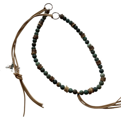 Necklace with beaded chain and brown leather cord on a white background