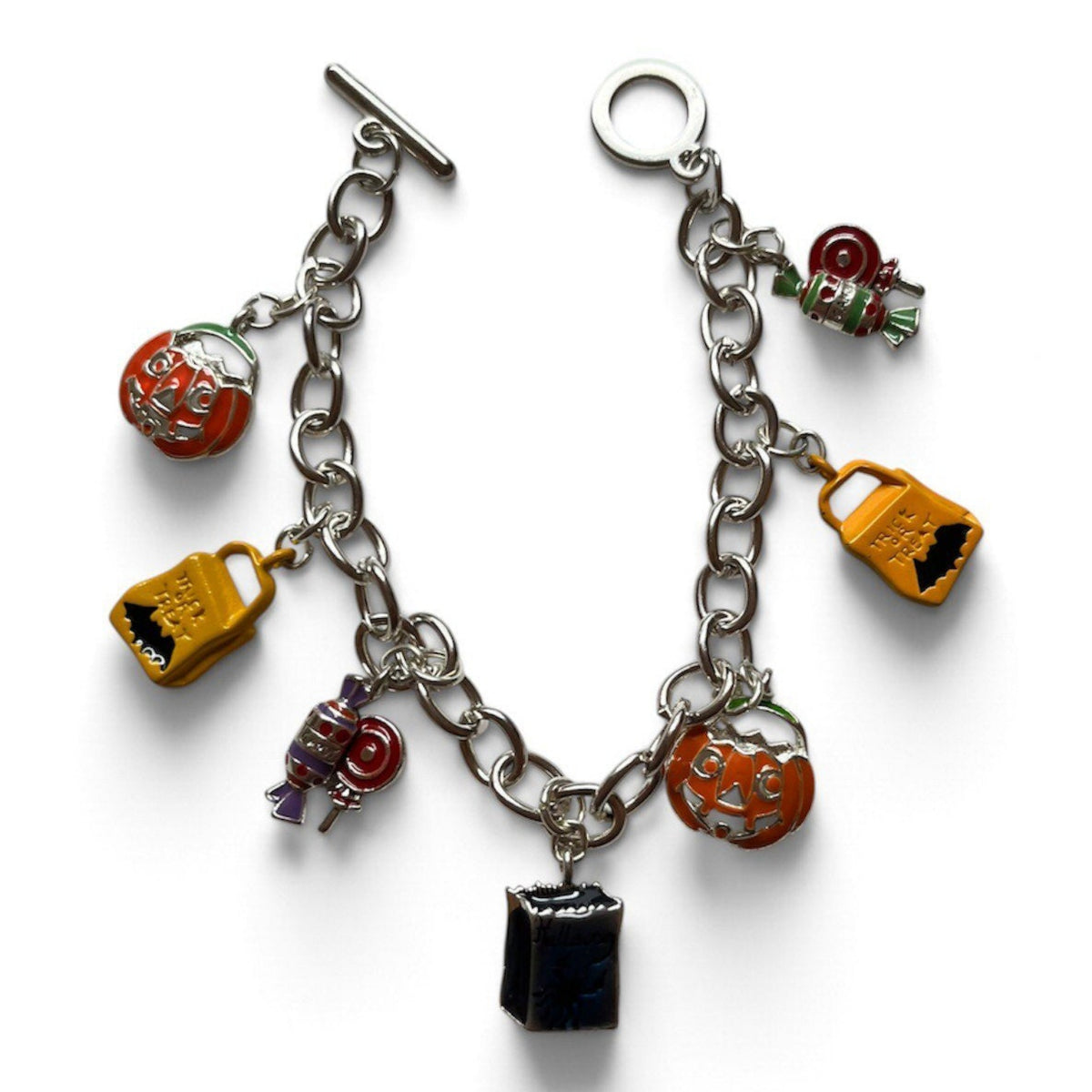 A silver-tone charm bracelet featuring multiple Halloween-themed enamel charms, including pumpkins, a cauldron, a key, and a small black box charm, displayed on a clean white background.