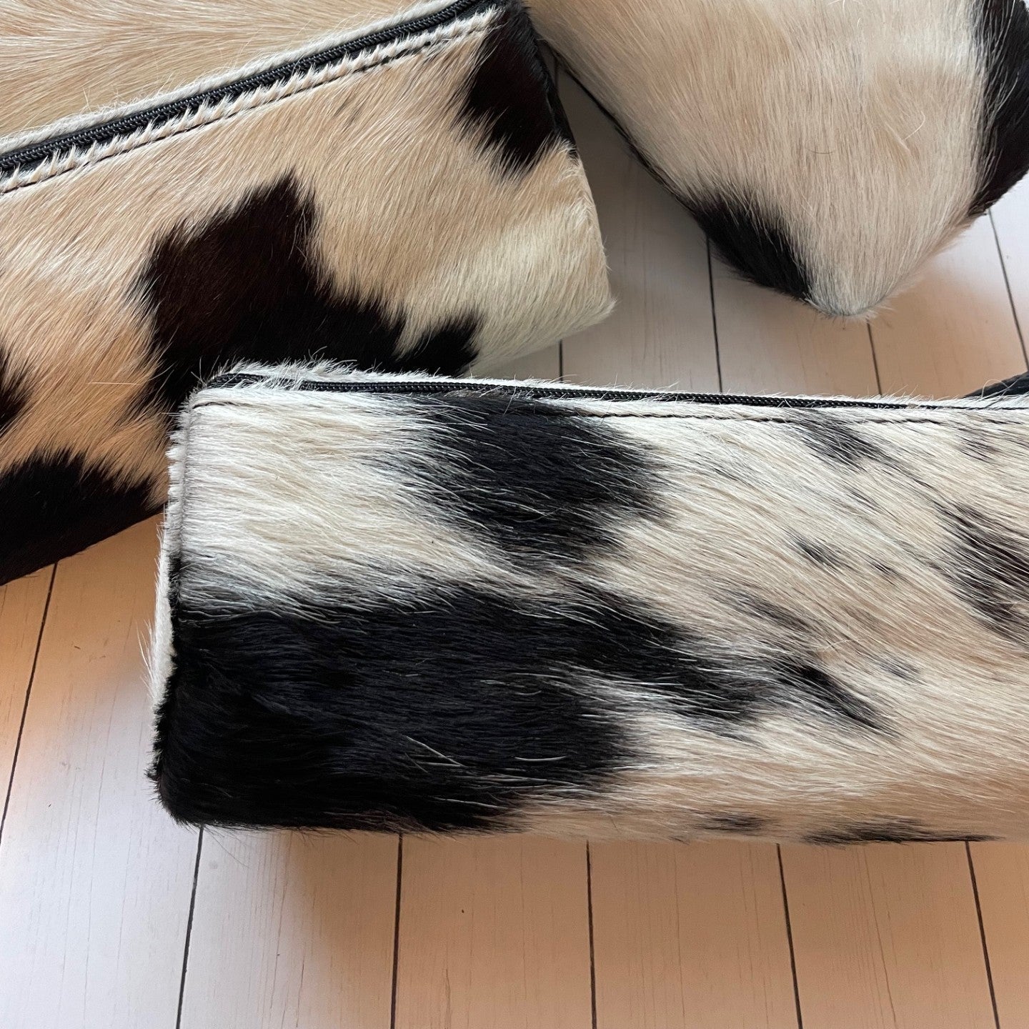 Black and white cowhide leather shoes on a wooden floor