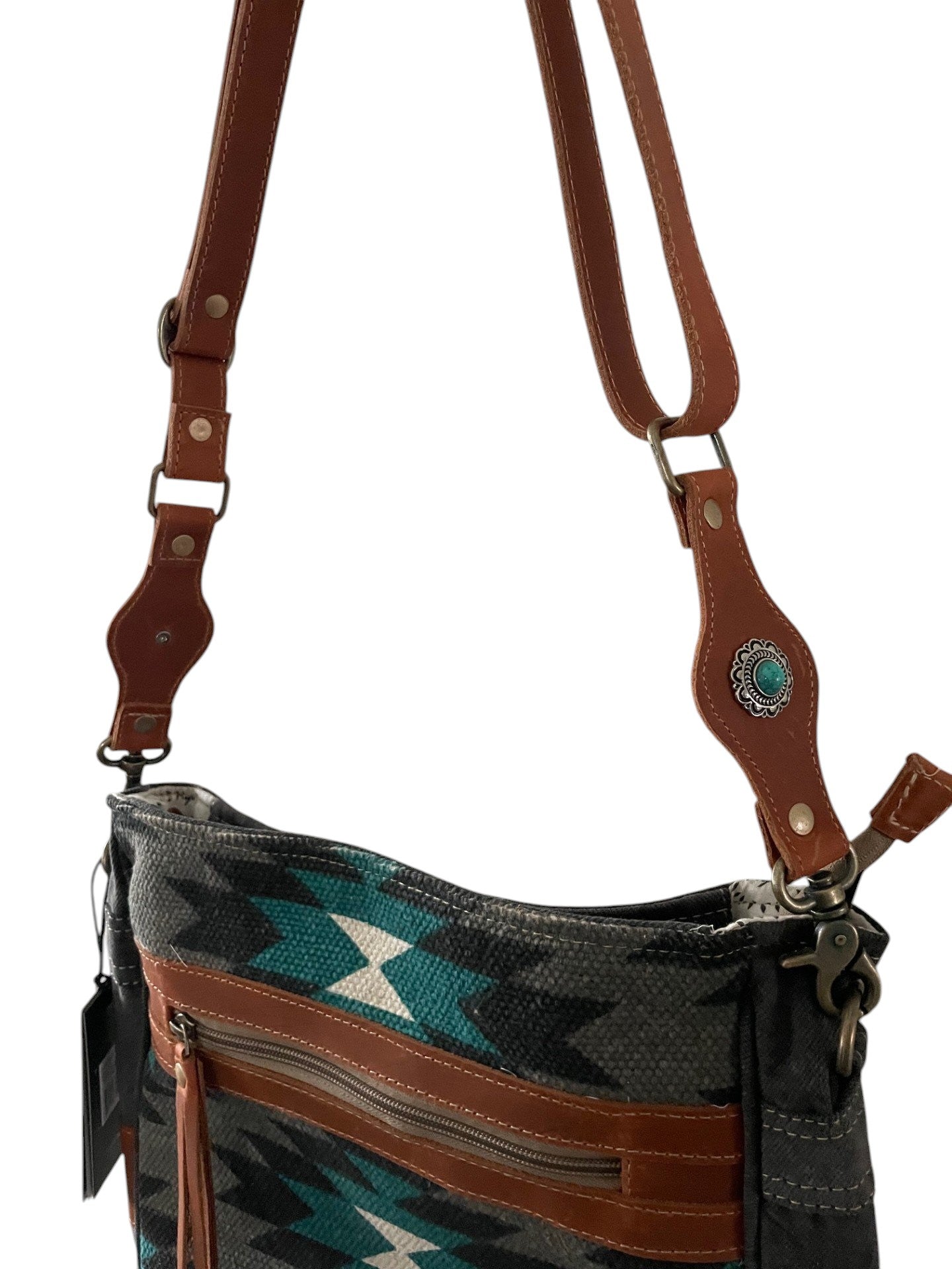 Handbag with a patterned flap and brown strap on a white background