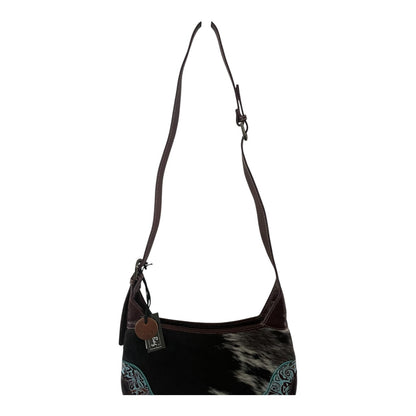 Black and brown handbag with cowhide pattern on a white background