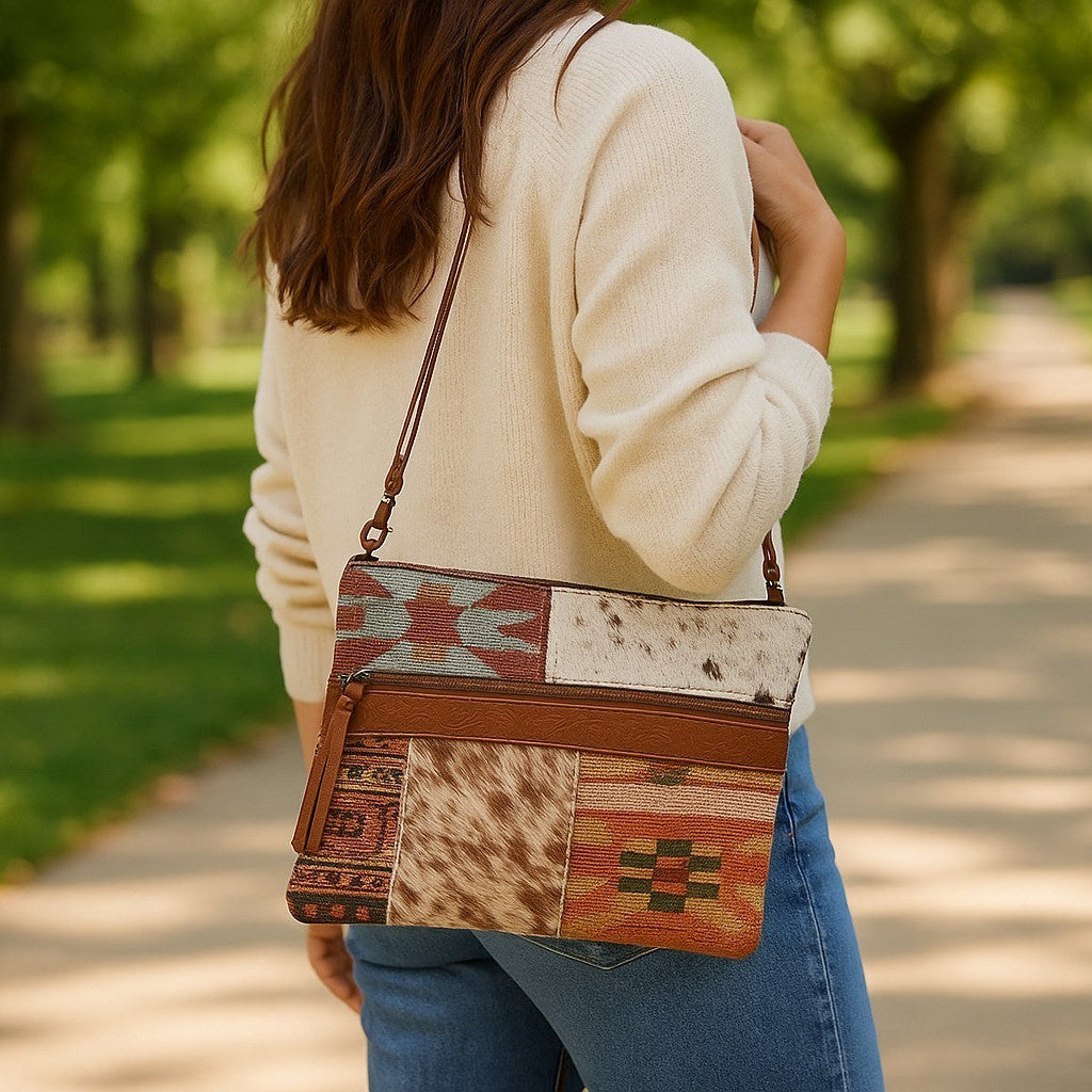 Person holding a patchwork handbag in a park