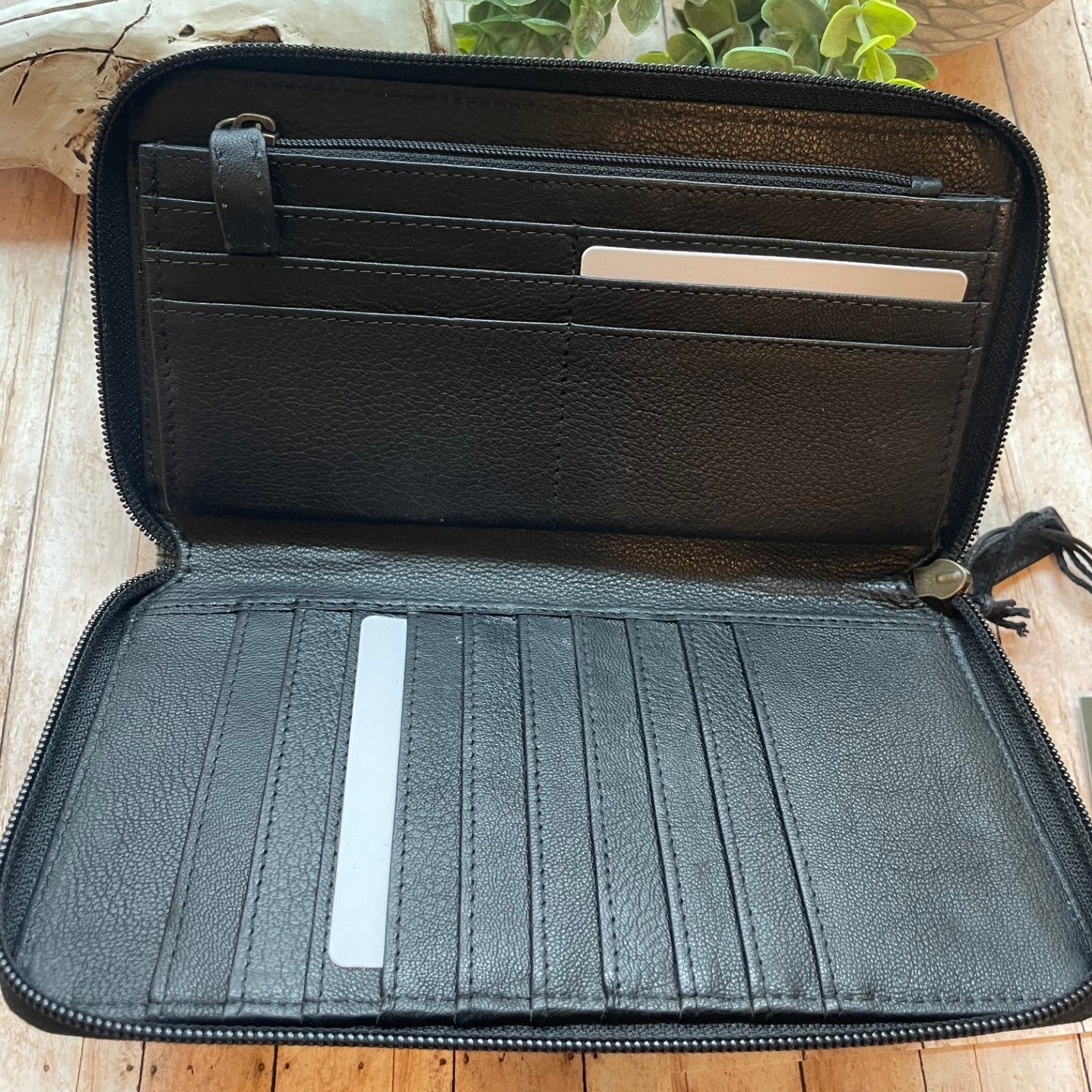 Black leather wallet with card slots on a wooden surface