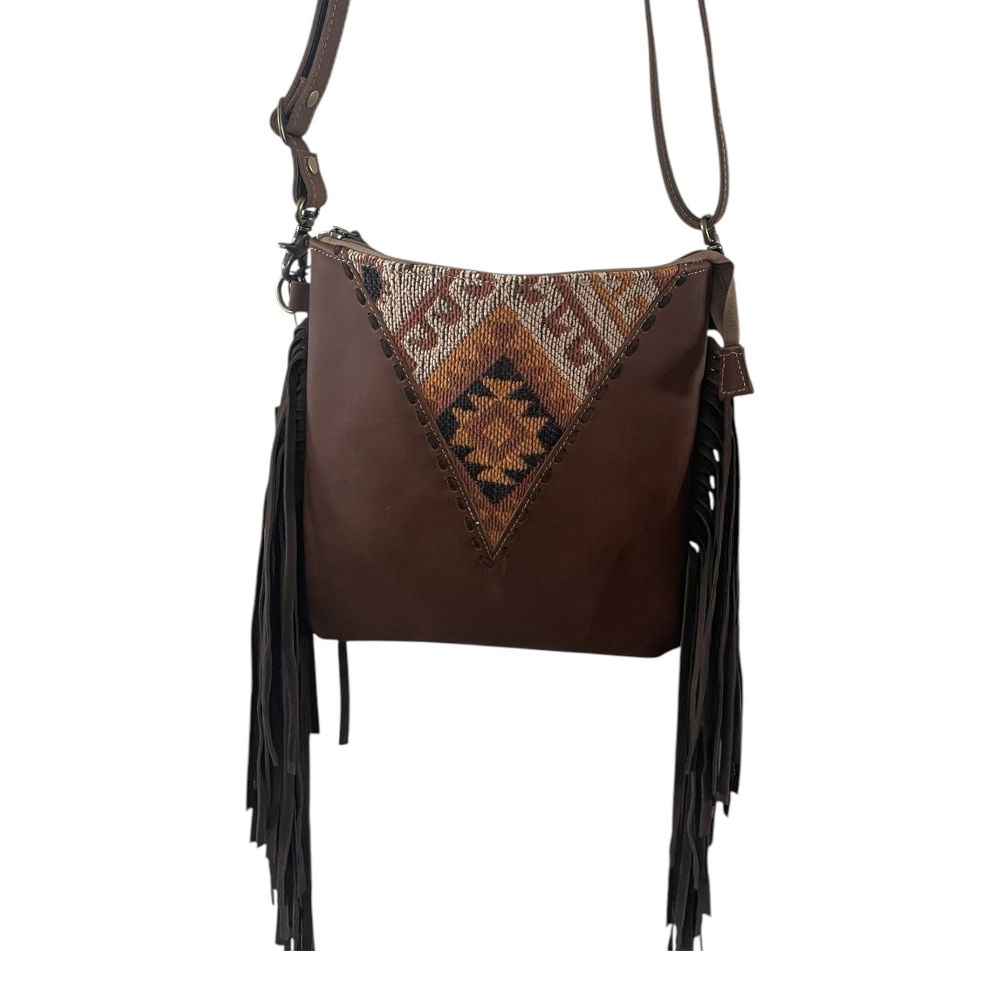 Brown leather handbag with patterned flap and fringes on a white background