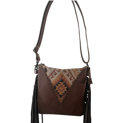 Brown leather handbag with patterned flap and fringes on a white background