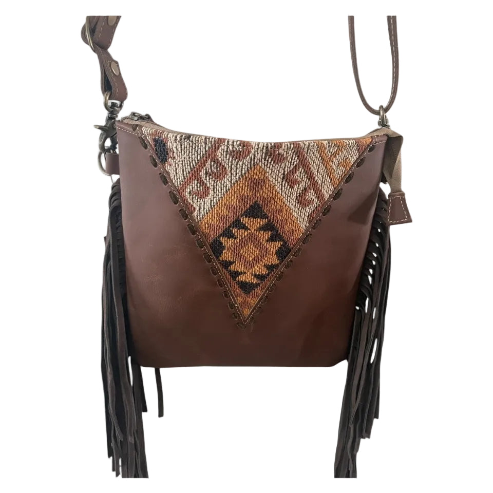 Brown leather handbag with tribal pattern and fringes on a white background