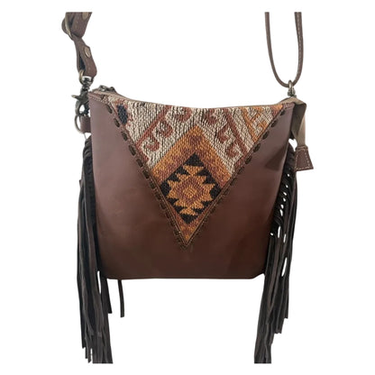 Brown leather handbag with tribal pattern and fringes on a white background