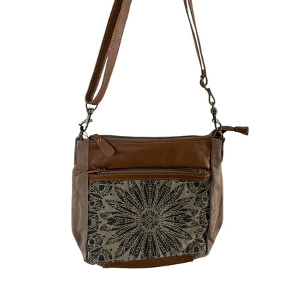 Brown leather handbag with a patterned flap on a white background