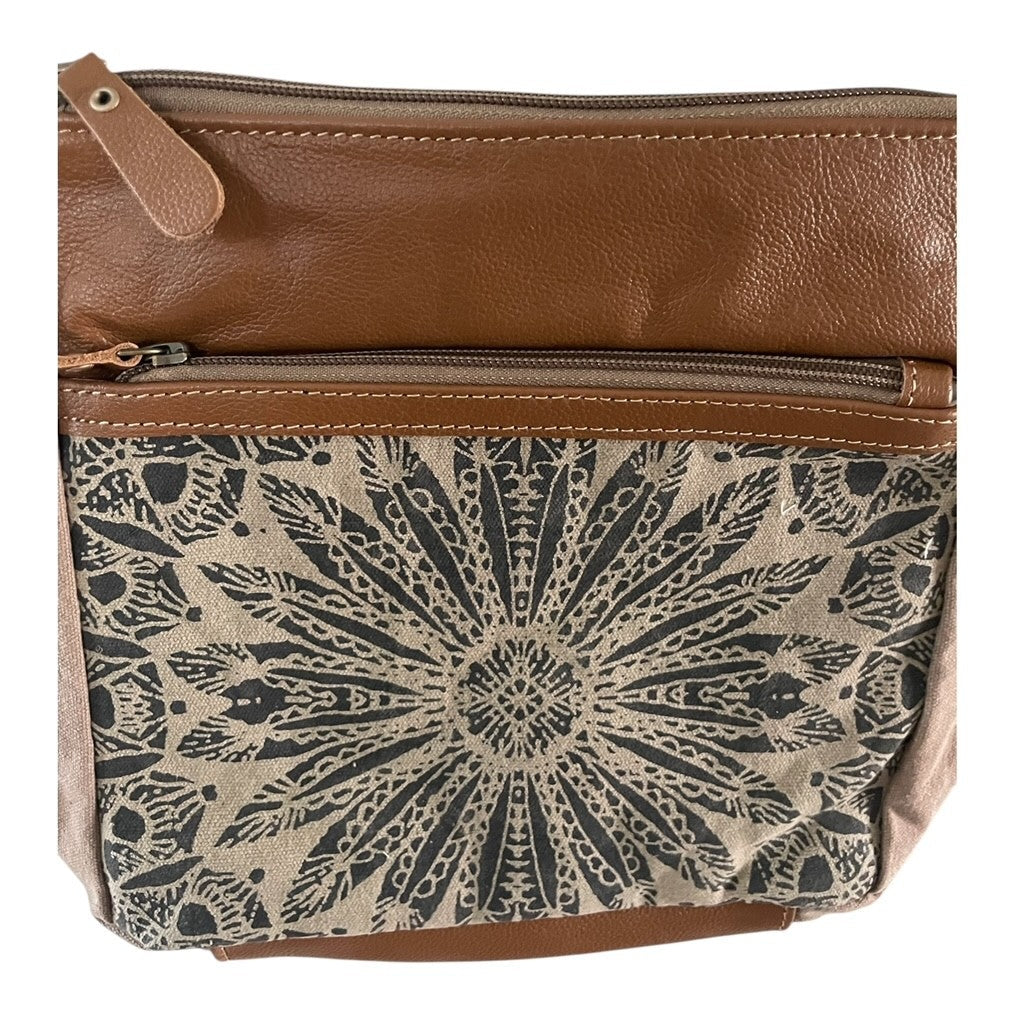 Brown leather crossbody bag with a patterned flap on a white background