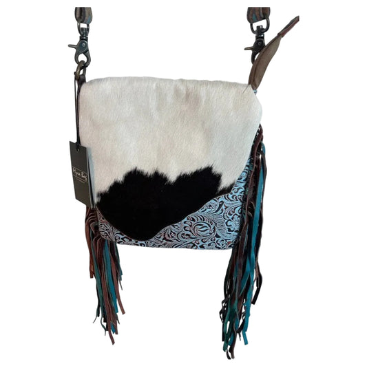 Cowhide leather bag with fringe details on a white background