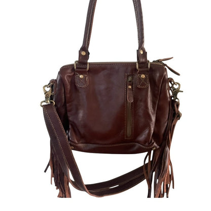 Brown leather handbag with fringe details and a zippered concealed carry area on a white background