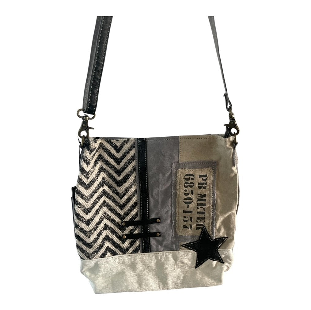 Crossbody bag with zigzag pattern, star design, and text on a white background
