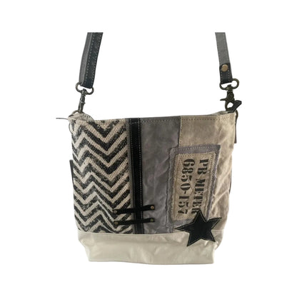 Patchwork-style handbag with zigzag pattern and star design on a white background