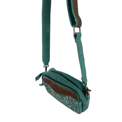 Teal crossbody bag with decorative elements on a white background