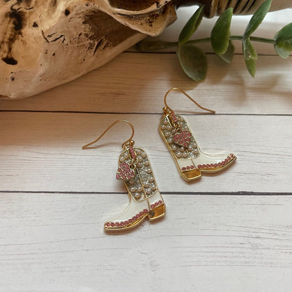 Decorative earrings on a wooden surface with natural elements.