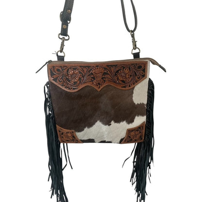 Cowhide leather handbag with fringe and intricate design on a white background