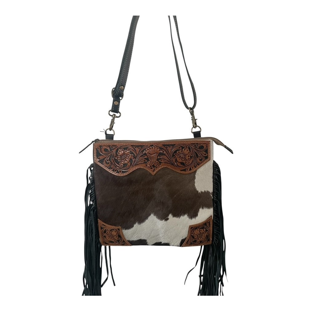 Cowhide leather handbag with fringe and decorative stitching on a white background