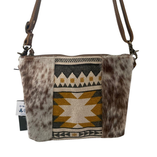 Crossbody bag with patterned fabric and fur accents on a white background