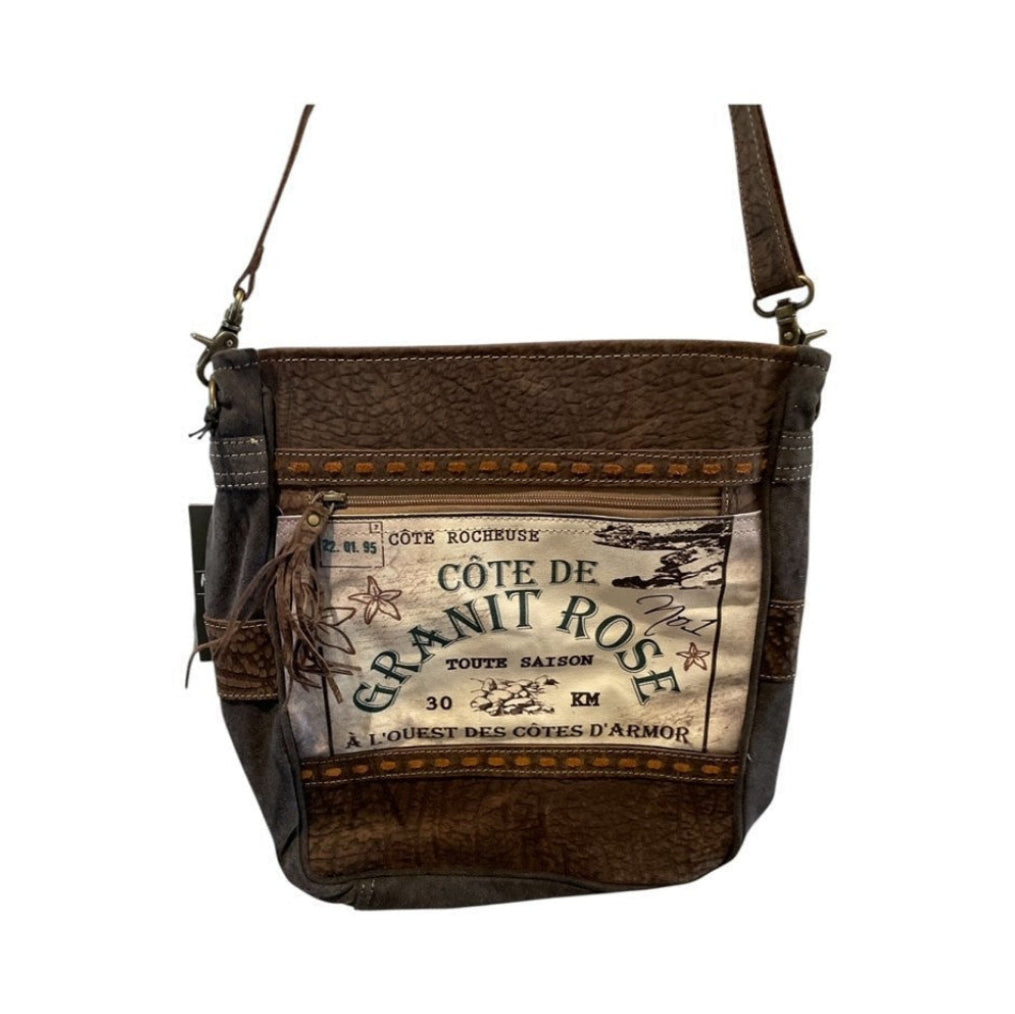 Brown leather handbag with a visible brand label on a white background