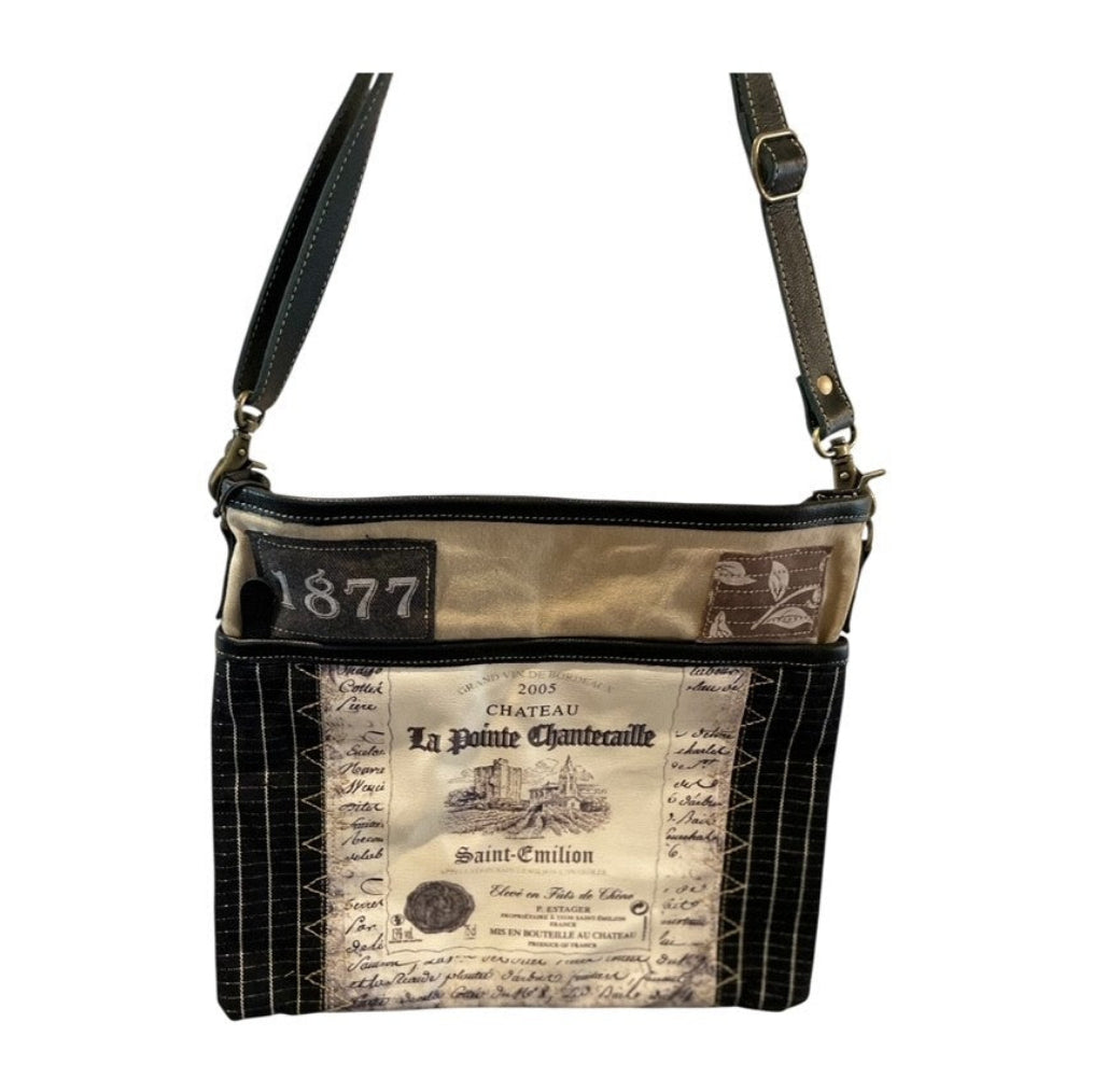 Crossbody bag with vintage-style label design on a white background