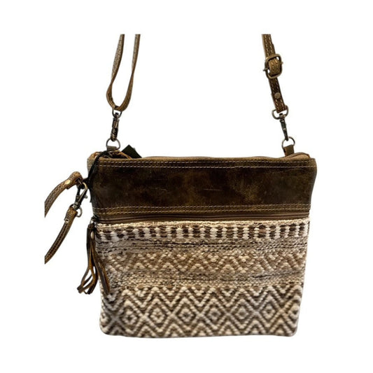 Brown leather crossbody bag with patterned flap on a white background