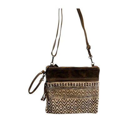 Brown crossbody bag with patterned design on a white background