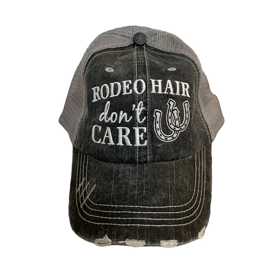 Black and gray cap with 'Rodeo Hair Don't Care' text and horseshoe design on a white background