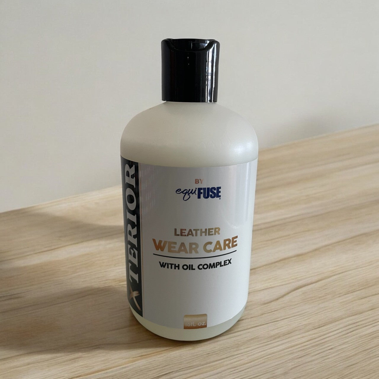 Bottle of leather wear care product on a wooden surface
