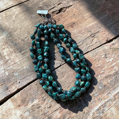 Turquoise beaded necklace on a wooden surface